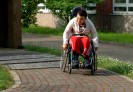 Ein Rollstuhlfahrer befährt eine Wegstrecke des Rollstuhlparcours.